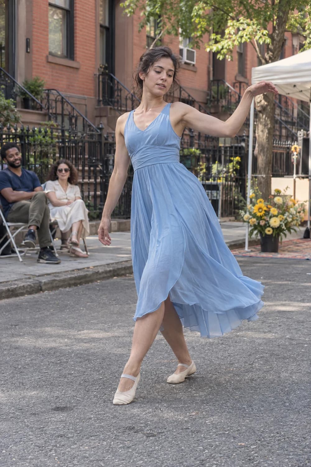 A dancer in a blue dress performing at an outdoor arts event