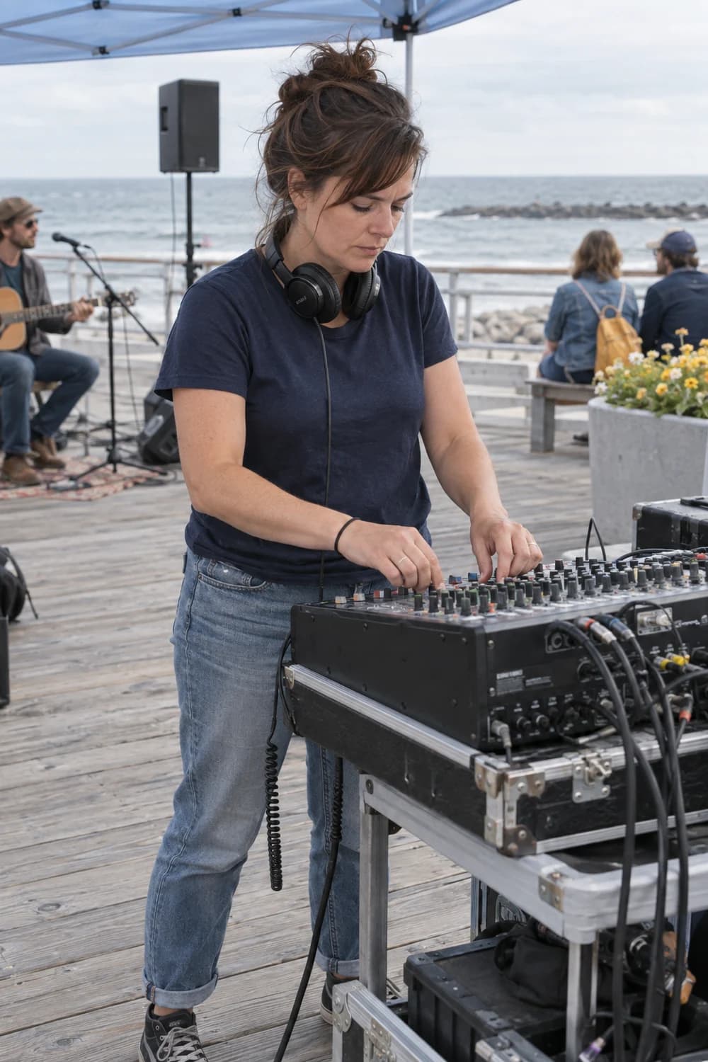 A sound technician at a mixing desk beside the boardwalk