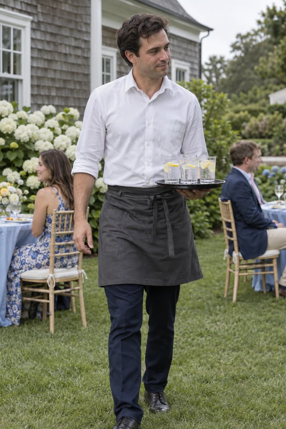 A waiter carrying drinks at an outdoor wedding